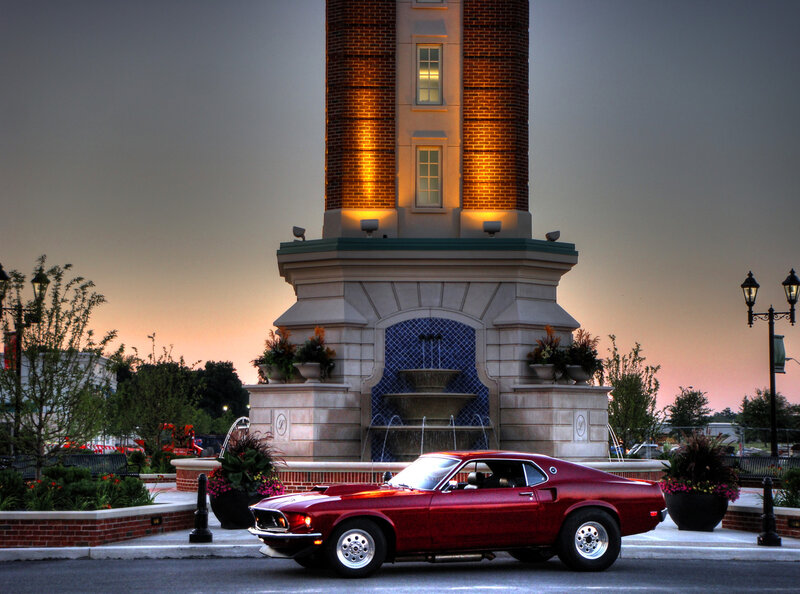 Red muscle car at fountain