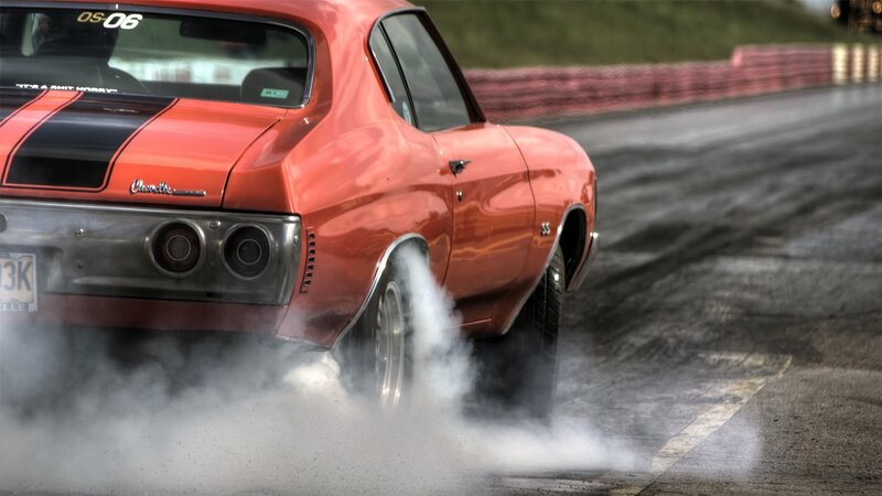 Red muscle car doing burnout