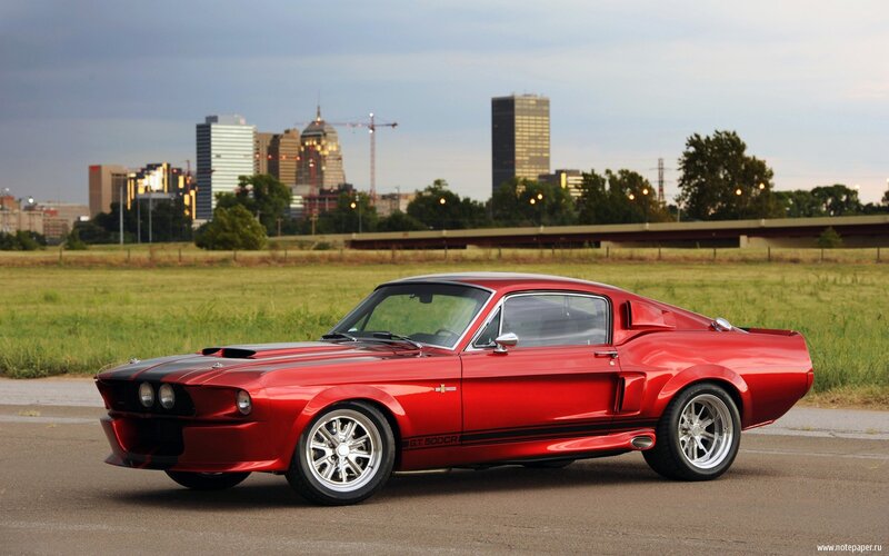 Red muscle car in cityscape
