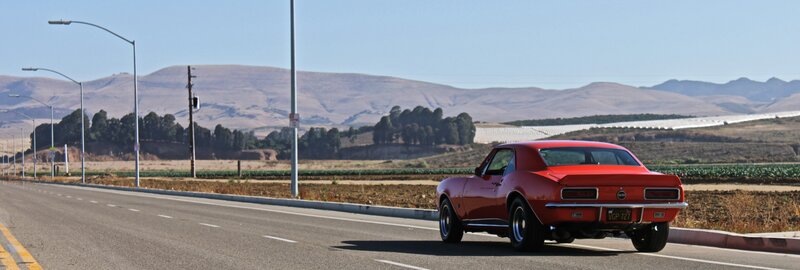 Red muscle car on a rural road