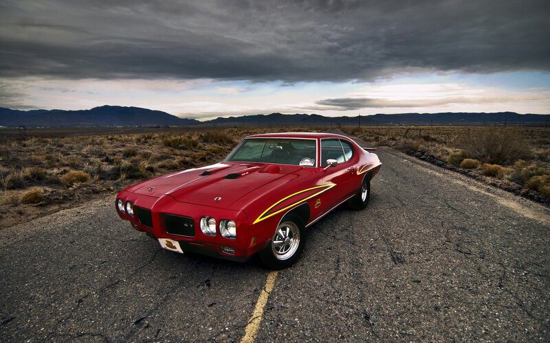 Red muscle car on desert road