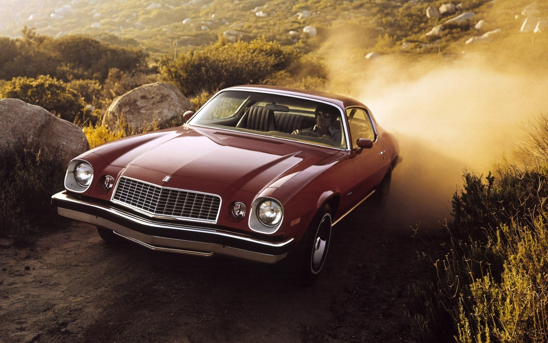 Red muscle car on dirt road