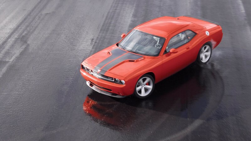 Red muscle car on wet pavement