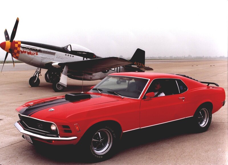 Red muscle car with vintage plane
