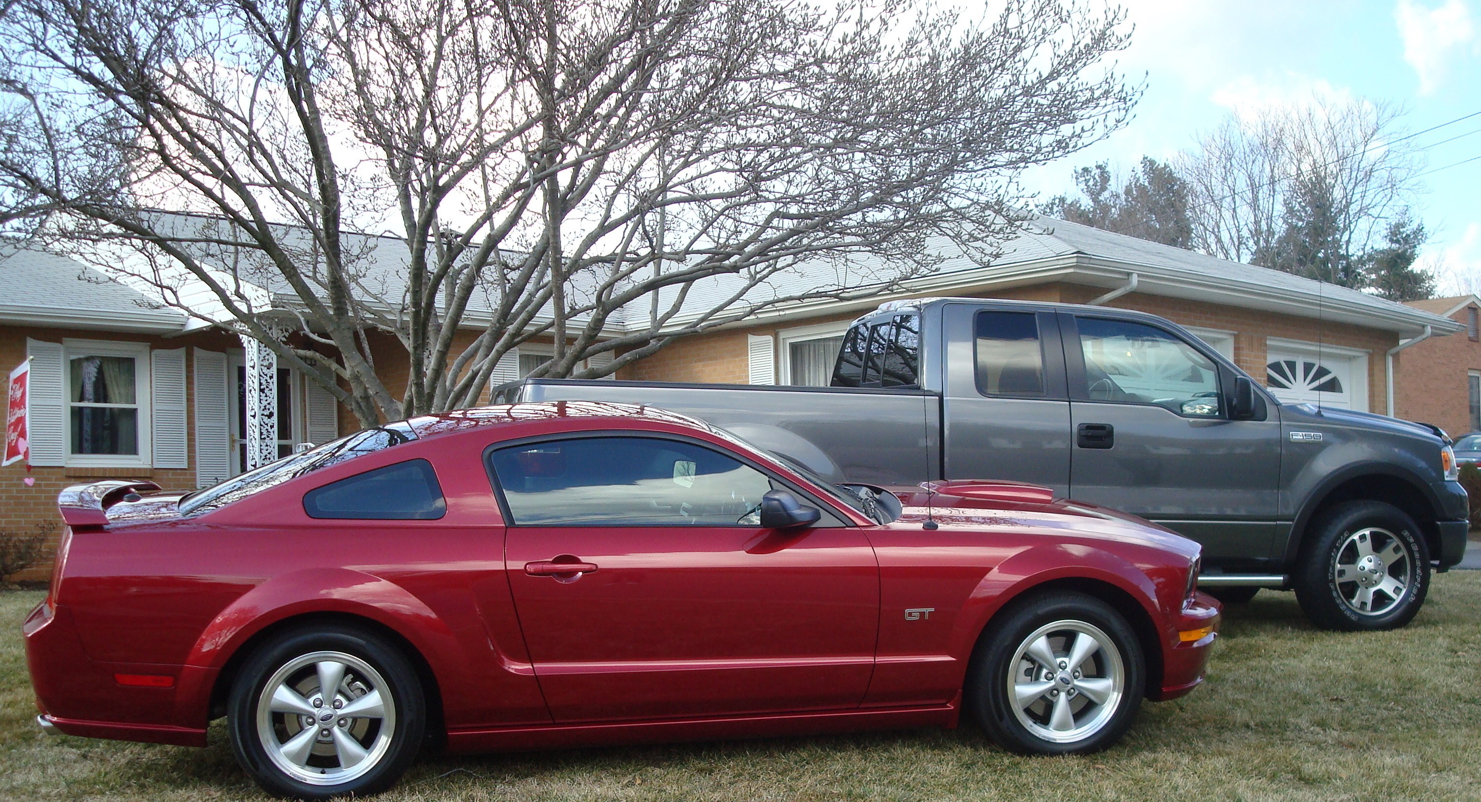 Red Mustang and gray truck