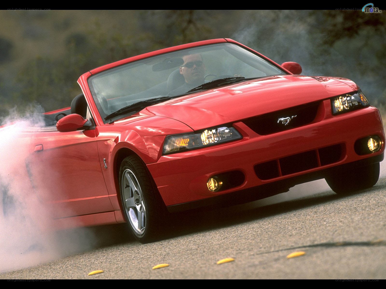 Red Mustang convertible in motion
