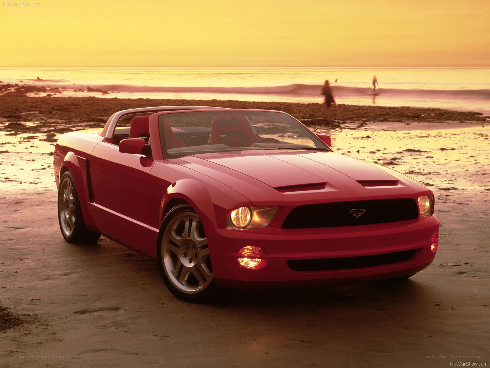 Red Mustang convertible on beach
