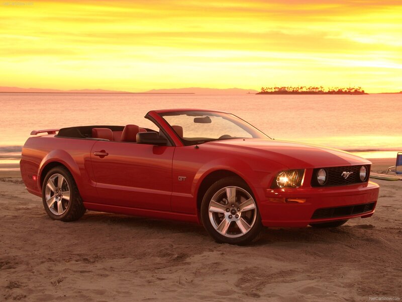 Red Mustang GT on beach at sunset