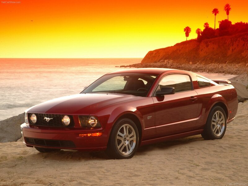 Red Mustang GT on beach at sunset