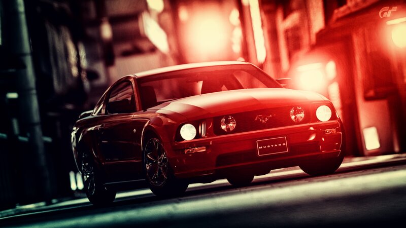 Red Mustang in city at night
