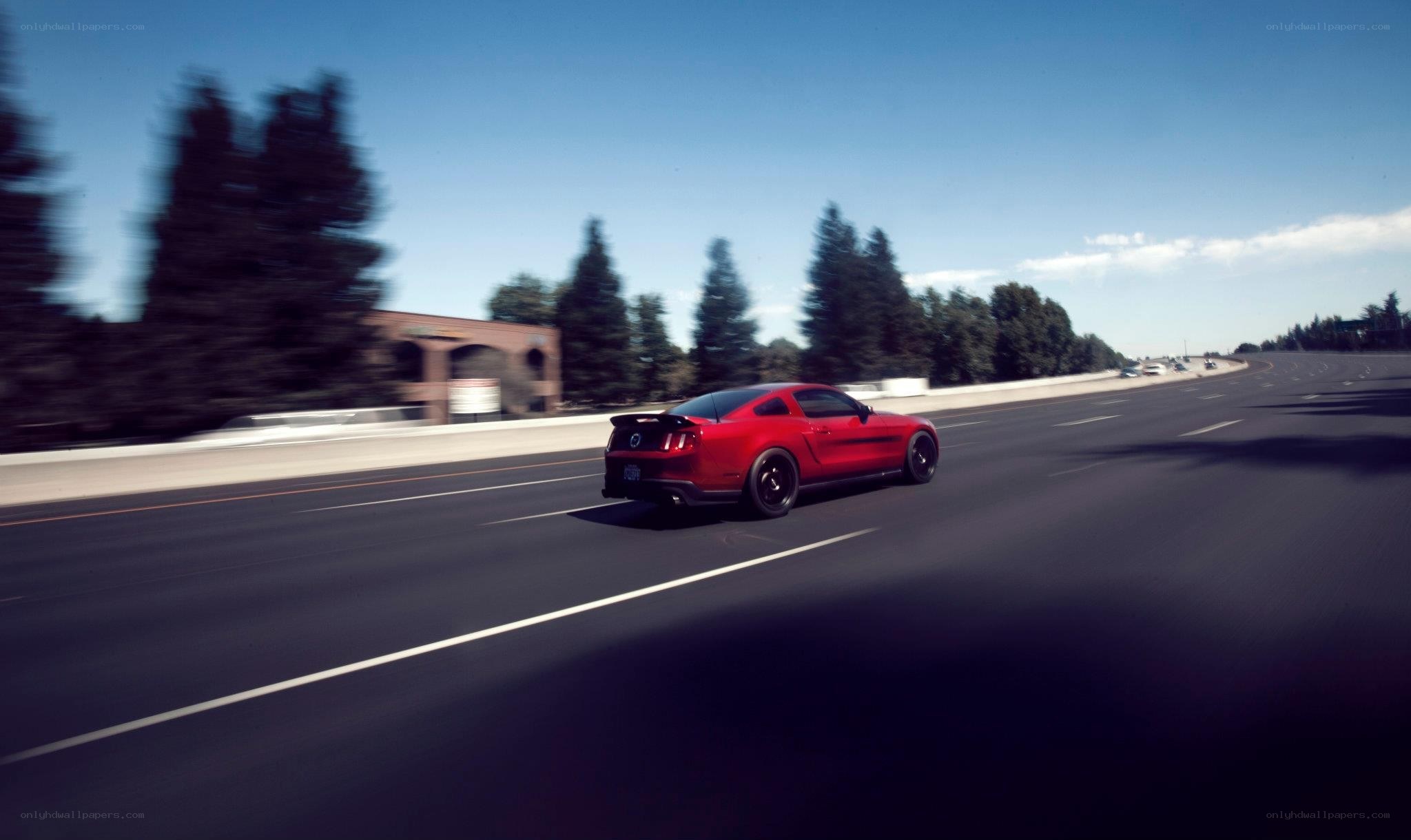 Red Mustang on a highway