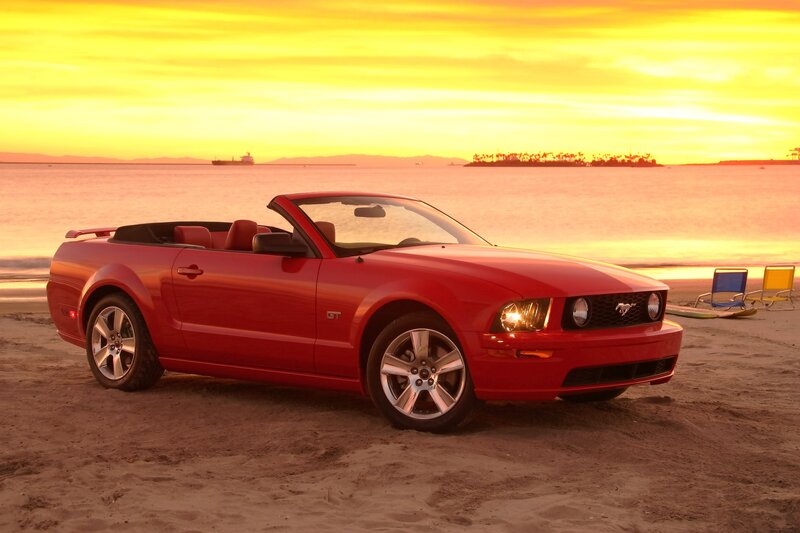 Red Mustang on beach at sunset