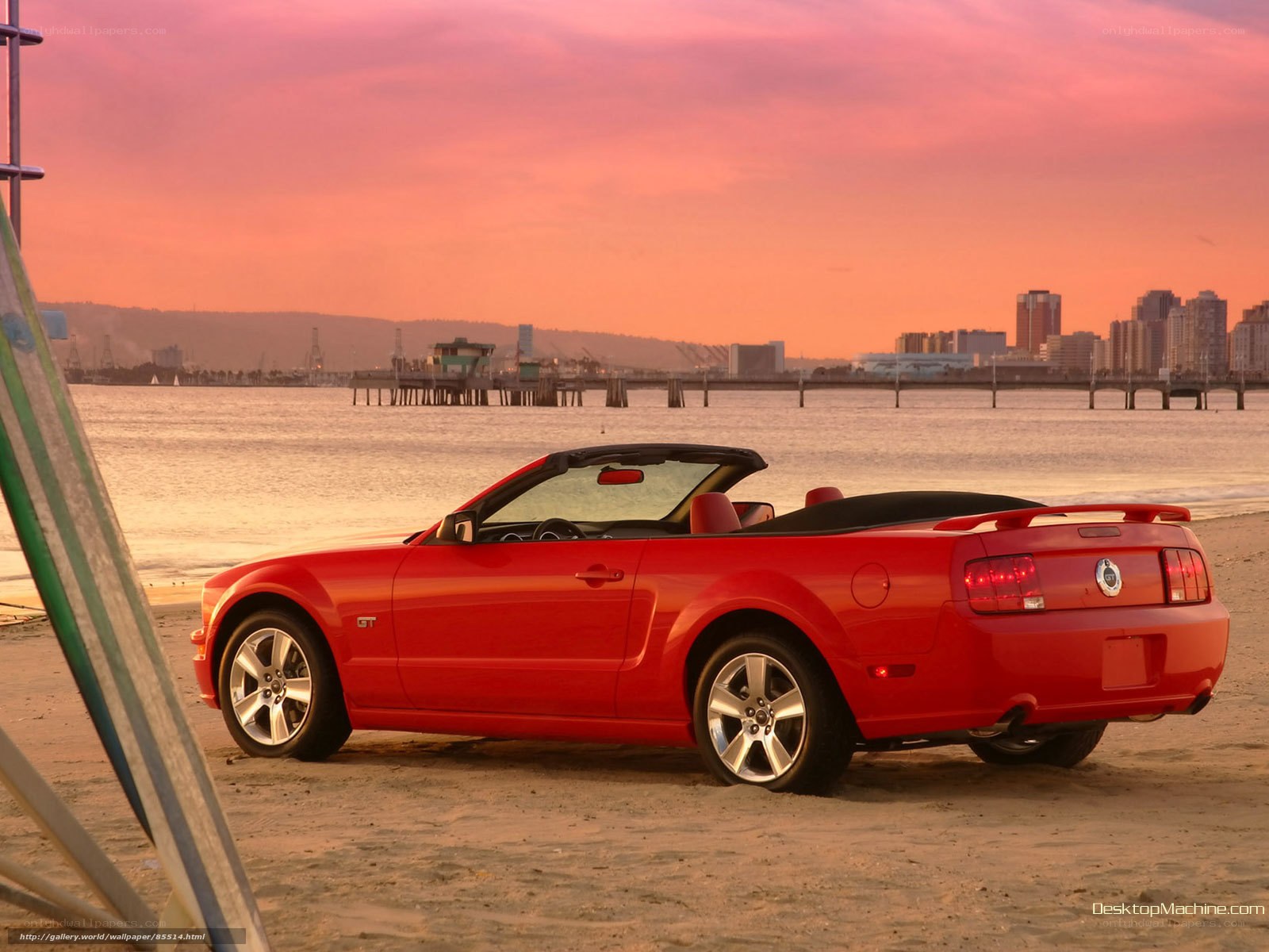 Red Mustang on beach at sunset