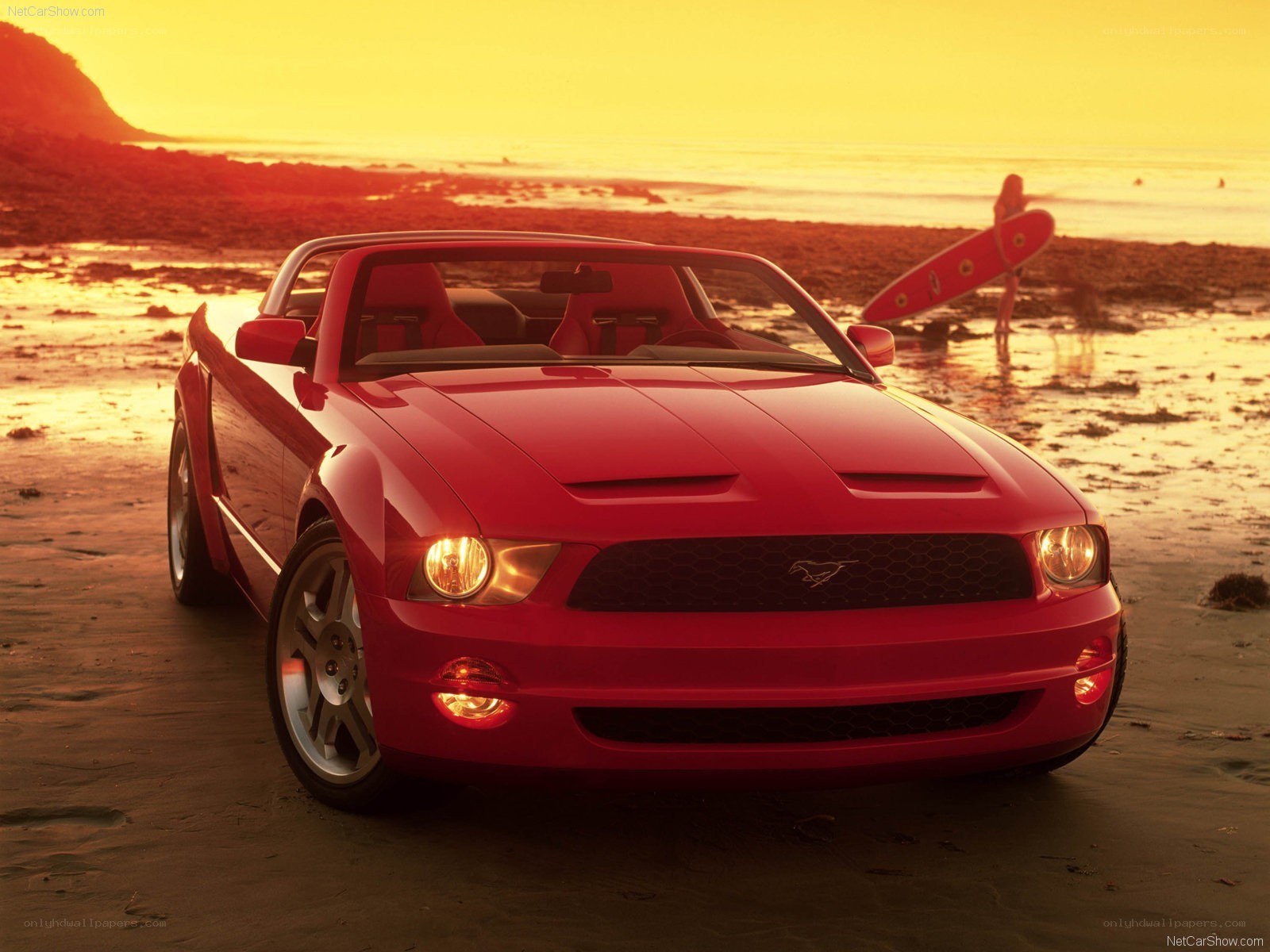 Red Mustang on beach at sunset