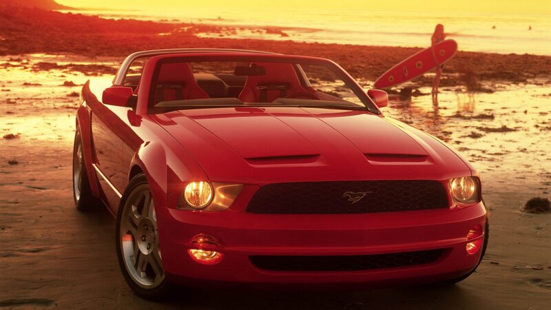 Red Mustang on beach at sunset