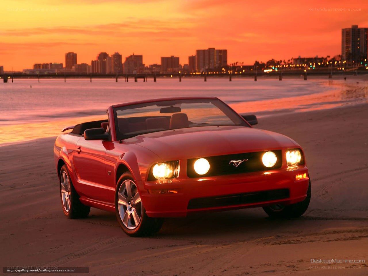 Red Mustang on beach at sunset