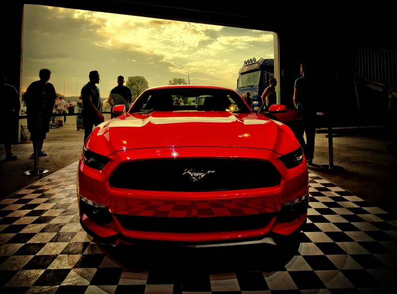 Red Mustang on checkered floor