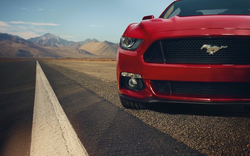 Red Mustang on desert road