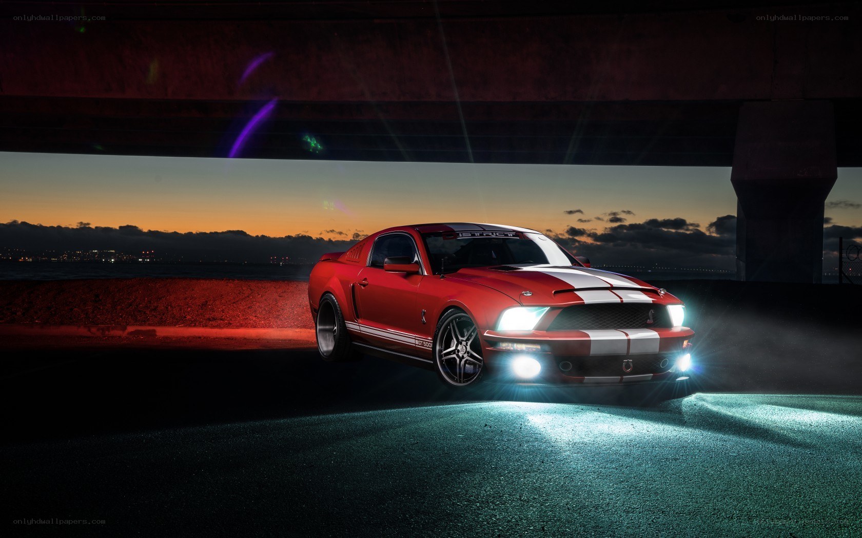 Red Mustang under a bridge