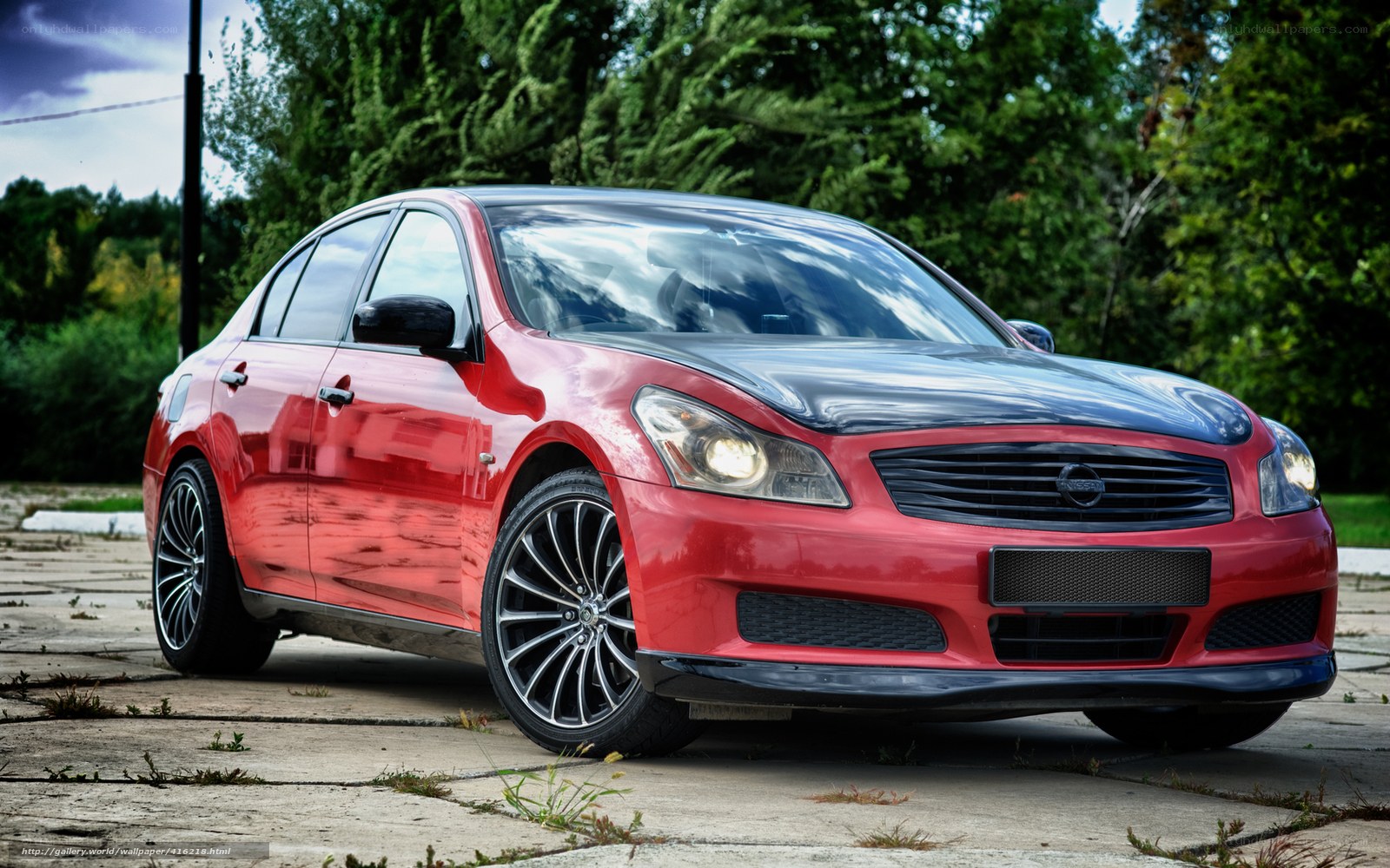 Red Nissan sedan on pavement