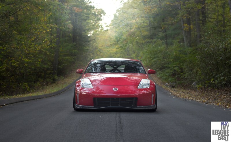 Red Nissan sports car on forest road