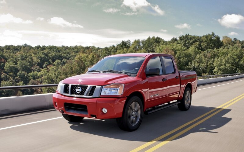 Red Nissan Titan on a highway