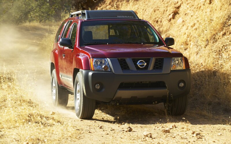 Red Nissan Xterra on dirt road
