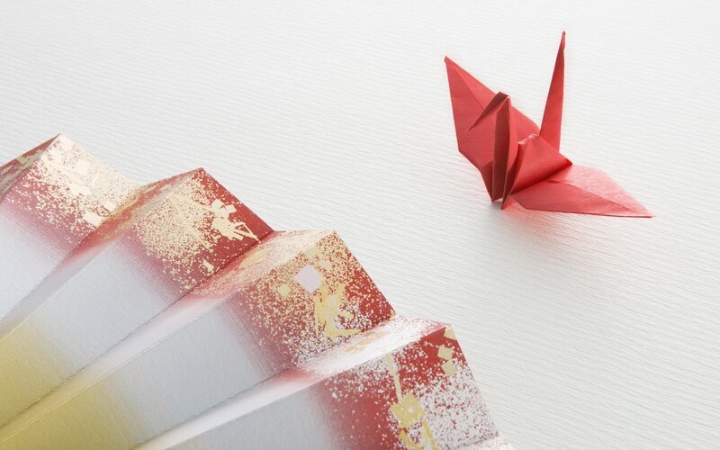 Red origami crane and fan