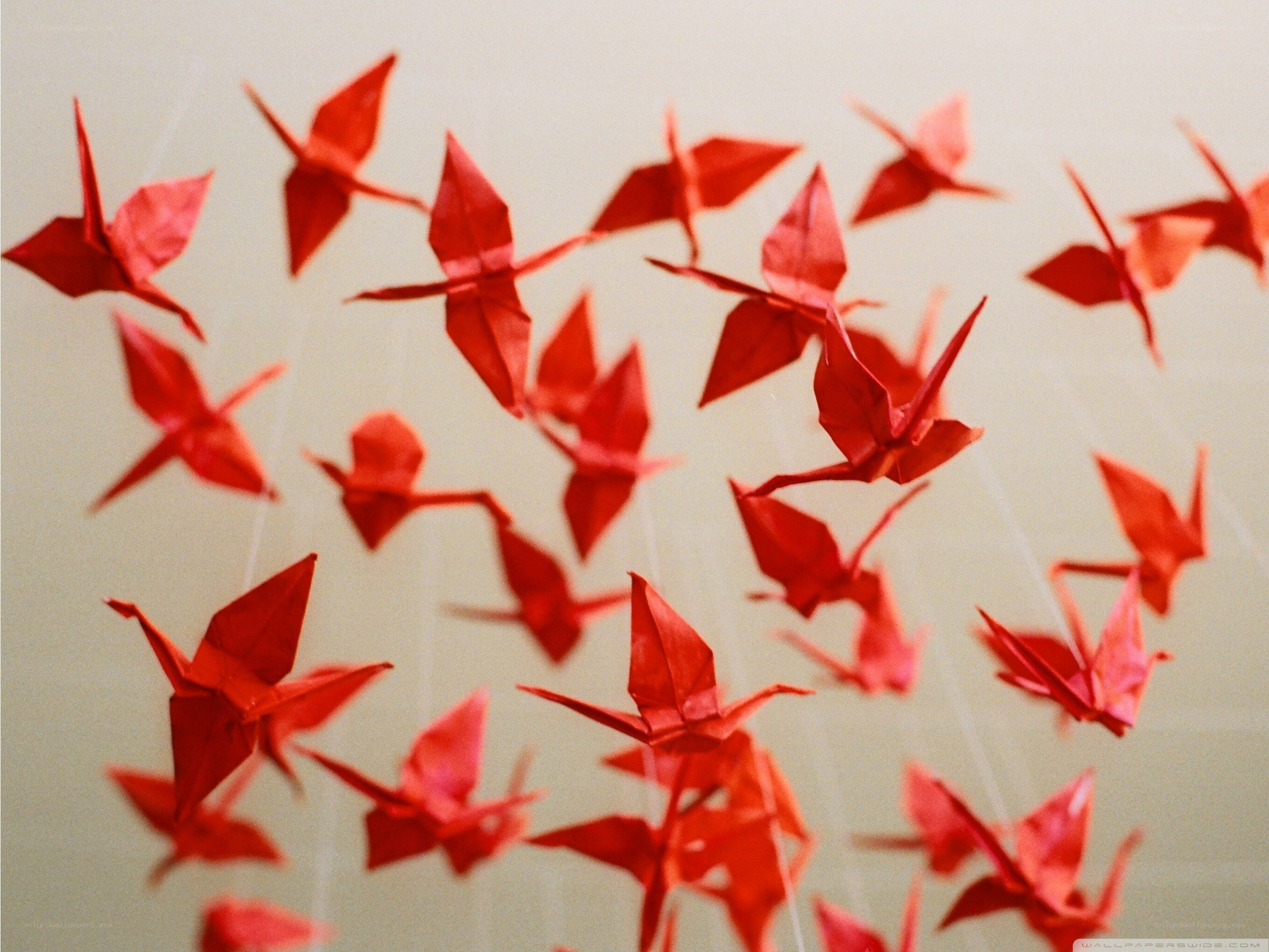 Red origami cranes in flight