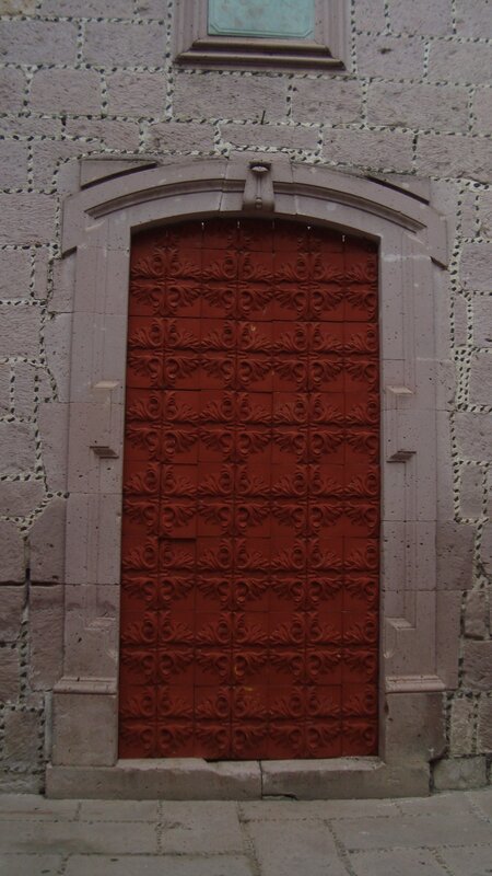 red ornate door on stone wall