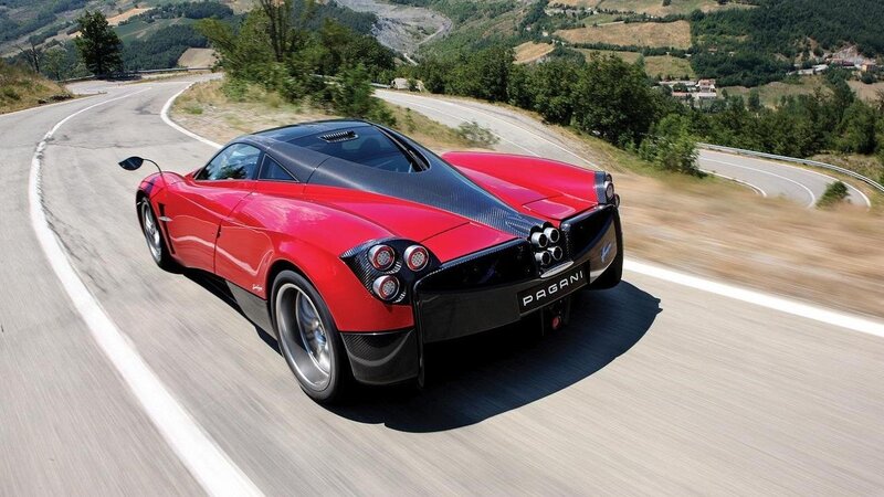 Red Pagani driving on a winding road