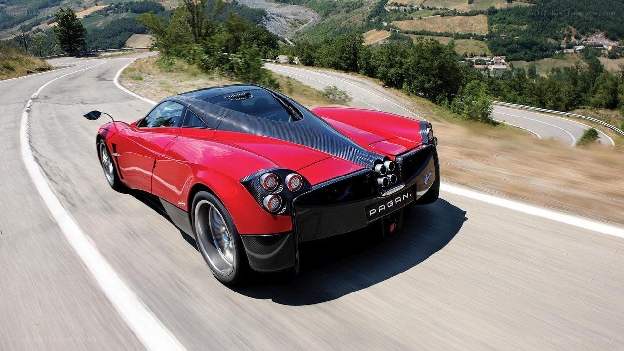 Red Pagani driving on a winding road