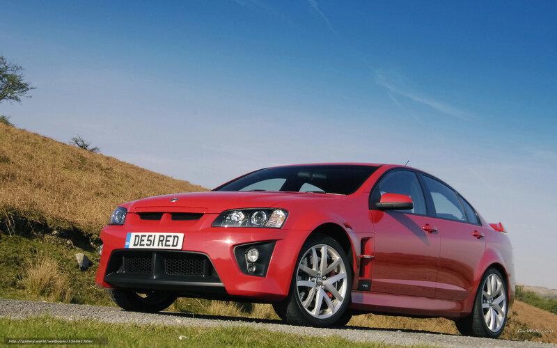 red performance sedan on hillside
