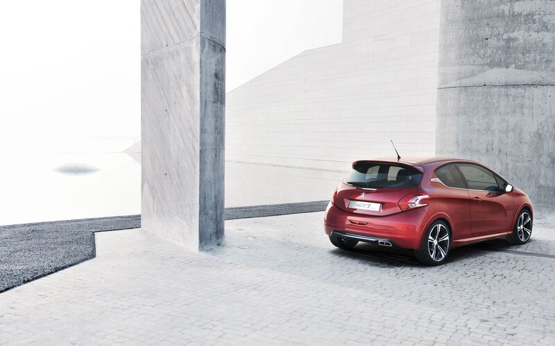 Red Peugeot car in modern setting