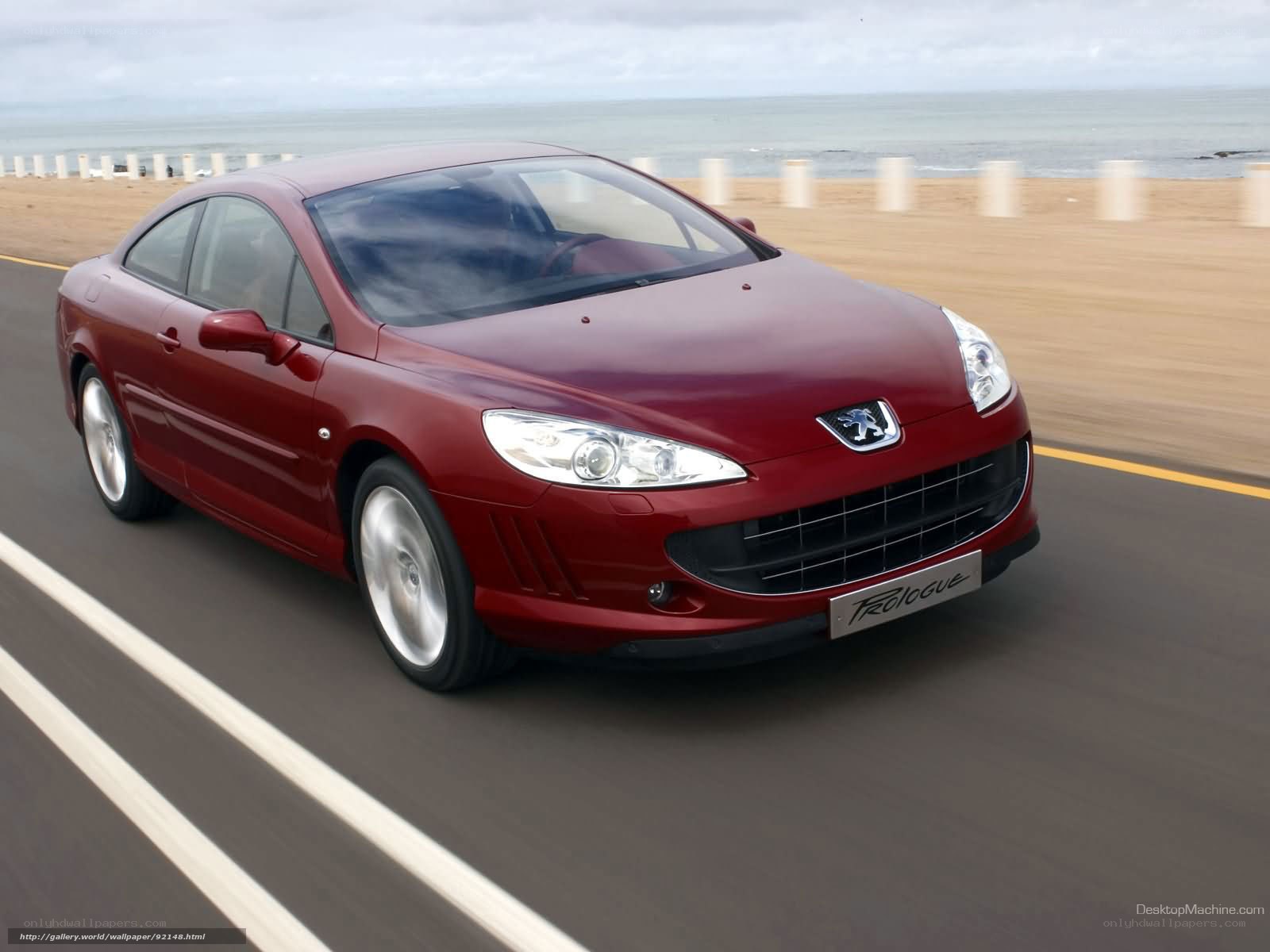 red peugeot coupe on coastal road