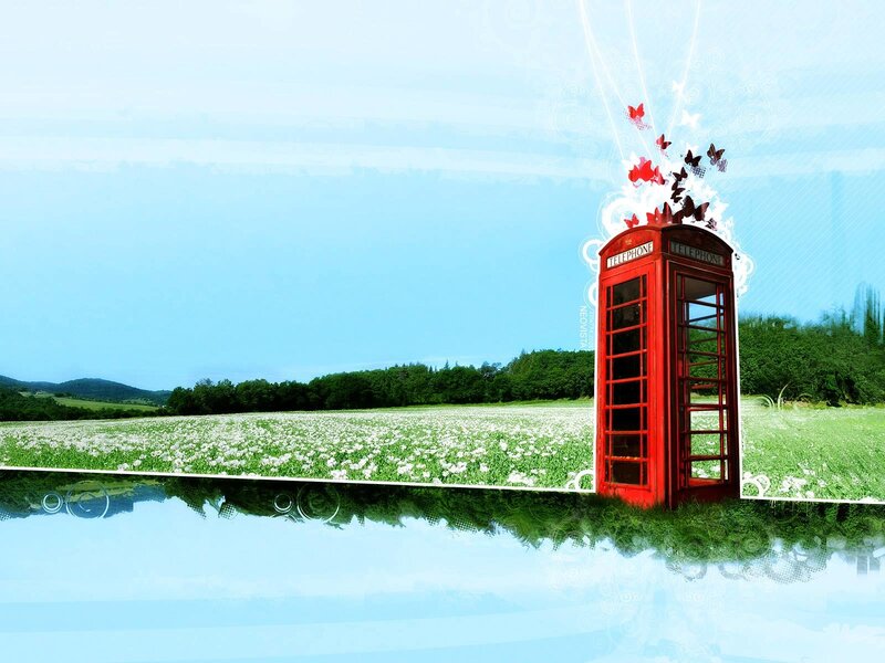Red phone booth in a field