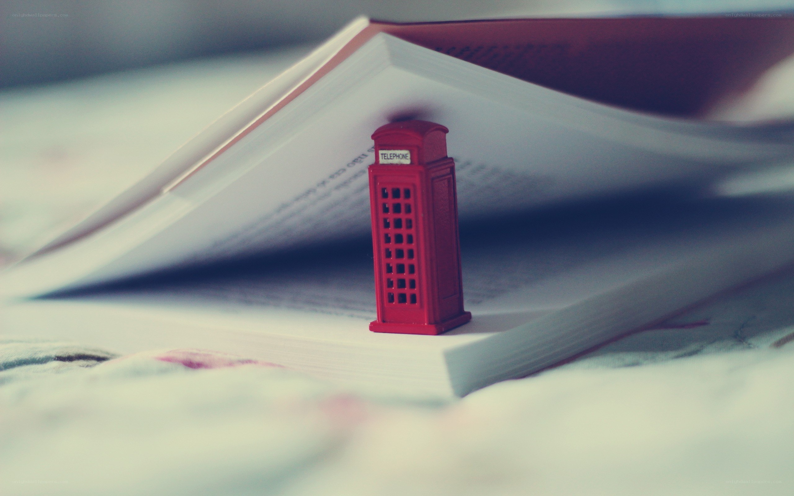Red phone booth on open book
