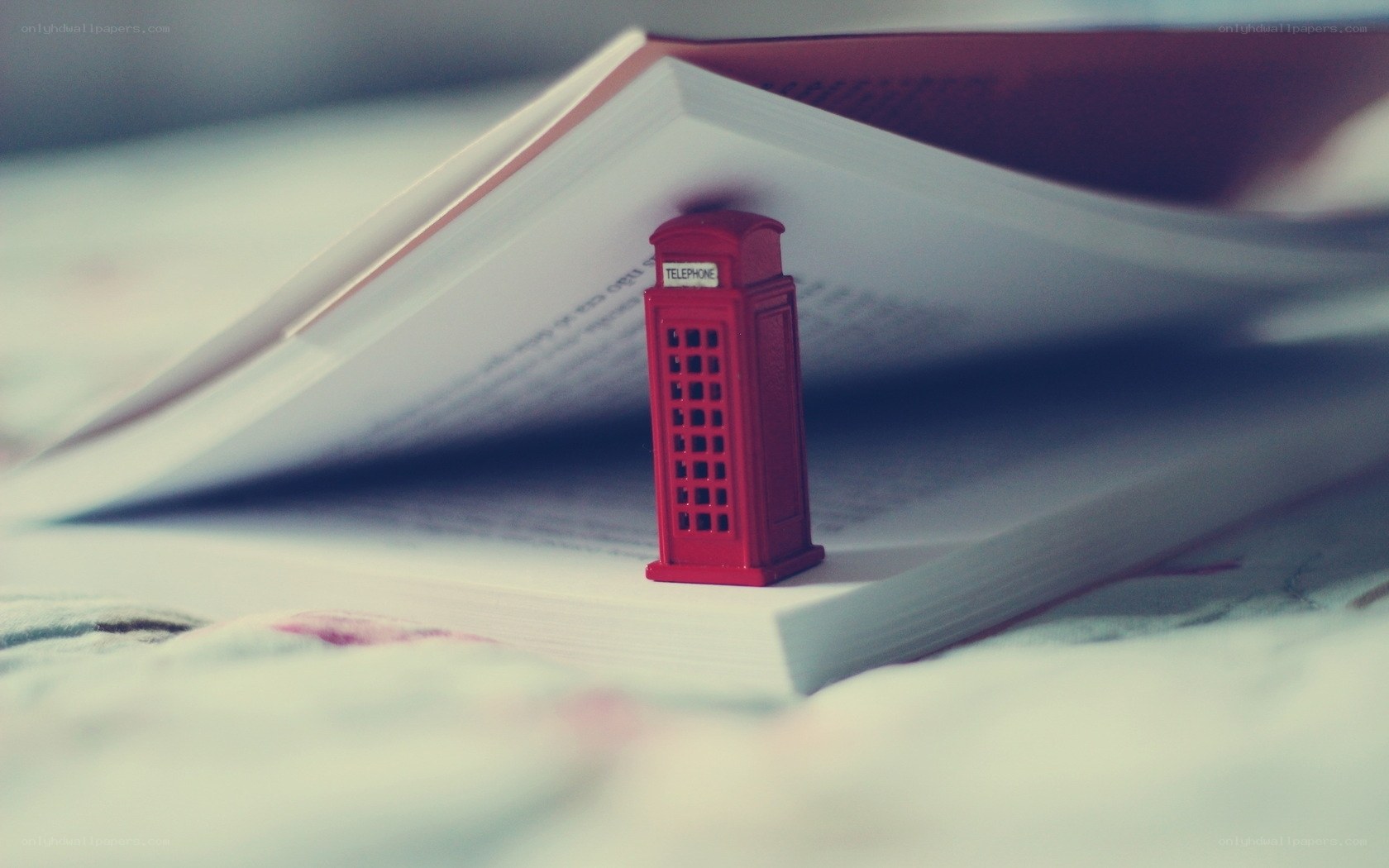 Red phone booth on open book