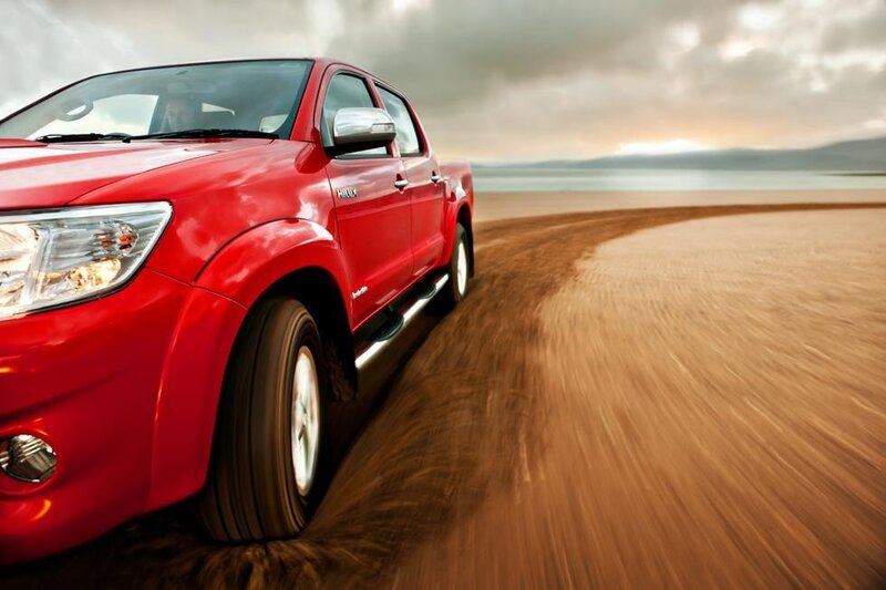 Red pickup truck on beach