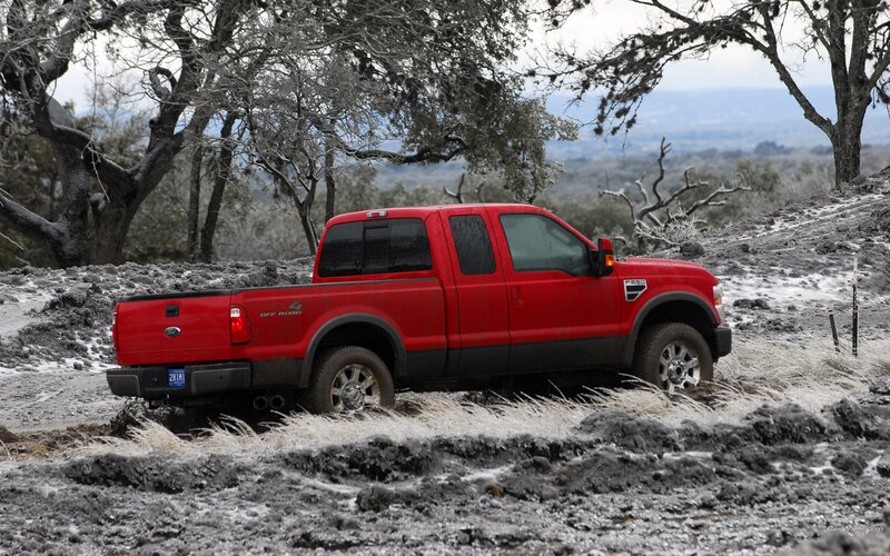 Red pickup truck on muddy terrain