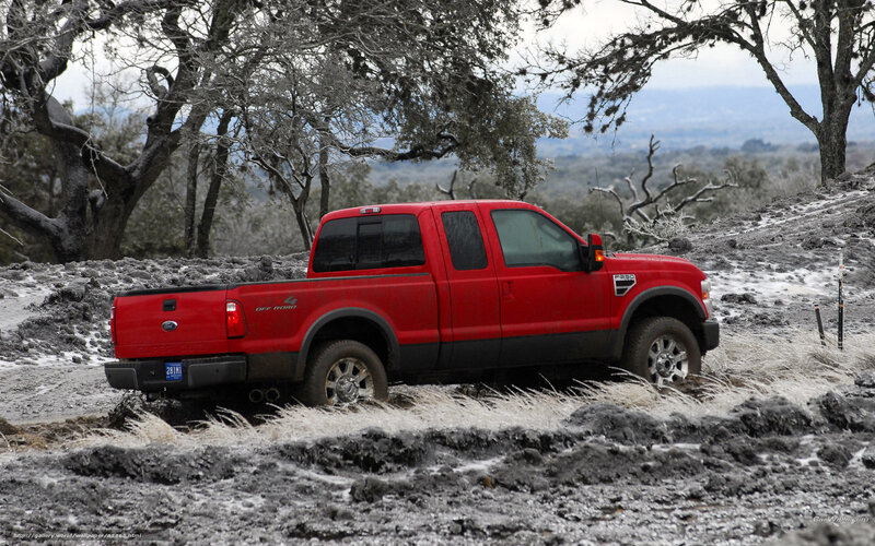 Red pickup truck on muddy terrain