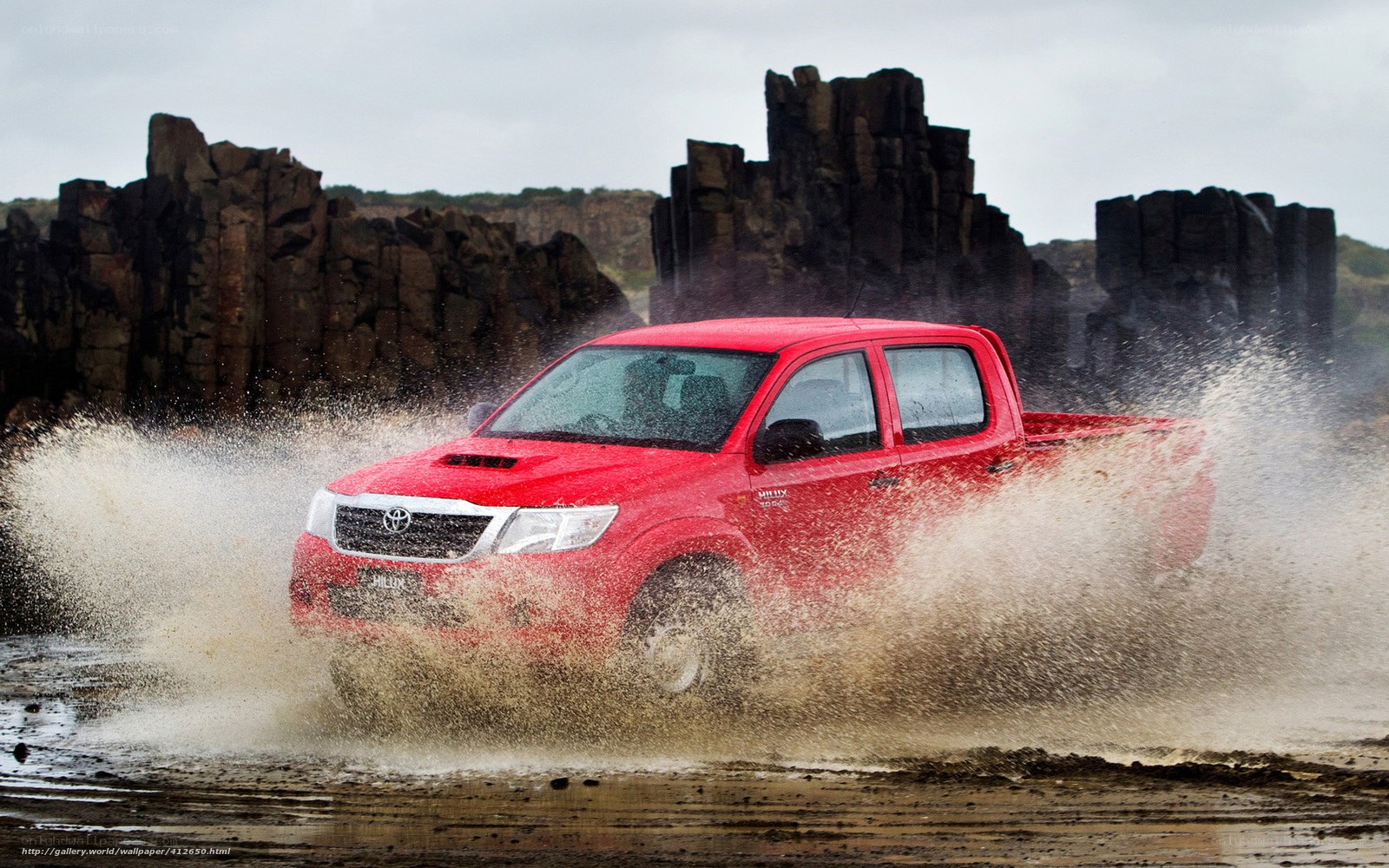 Red pickup truck splashing water
