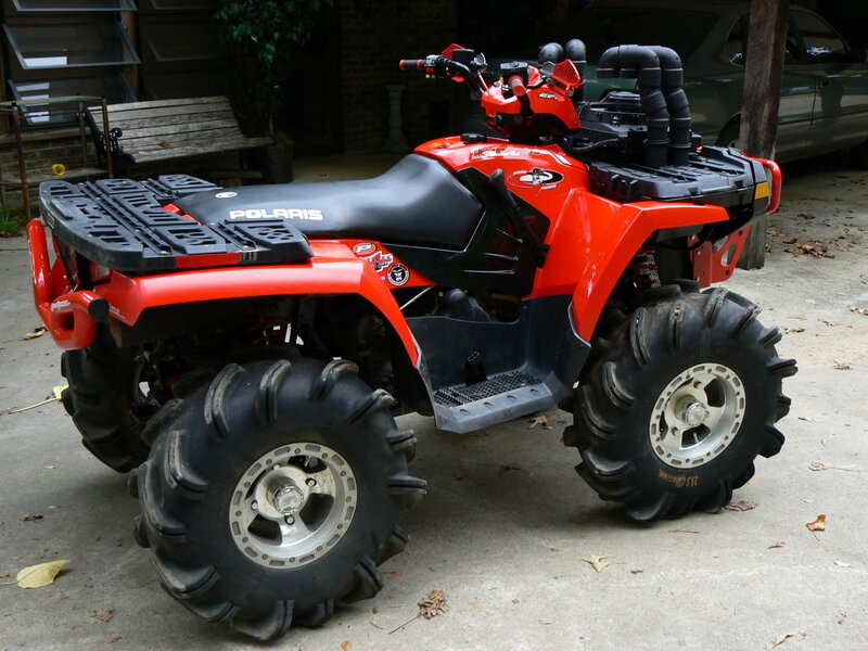 Red Polaris ATV parked outside