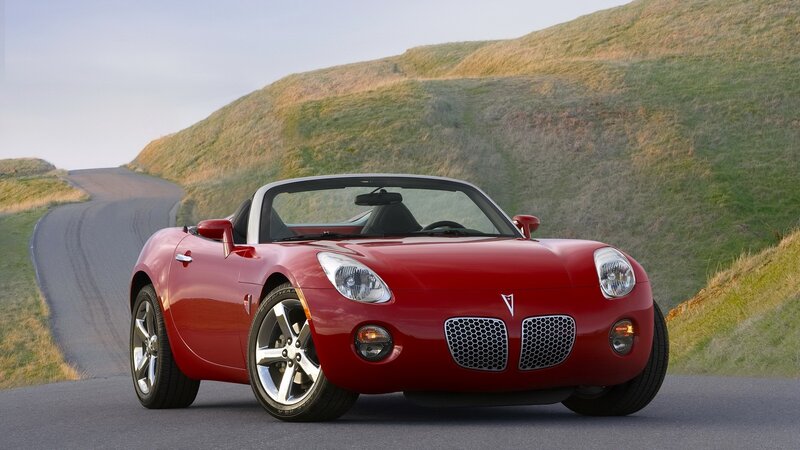 Red Pontiac Solstice on a winding road