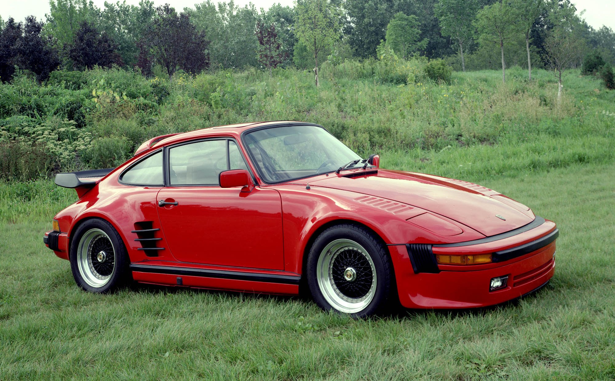 Red Porsche 930 in a field