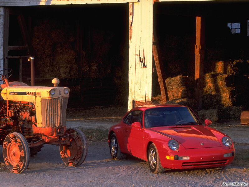 Red Porsche and tractor outside barn