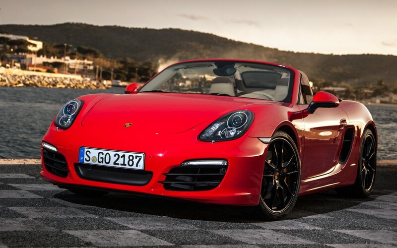 Red Porsche Boxster parked by the sea