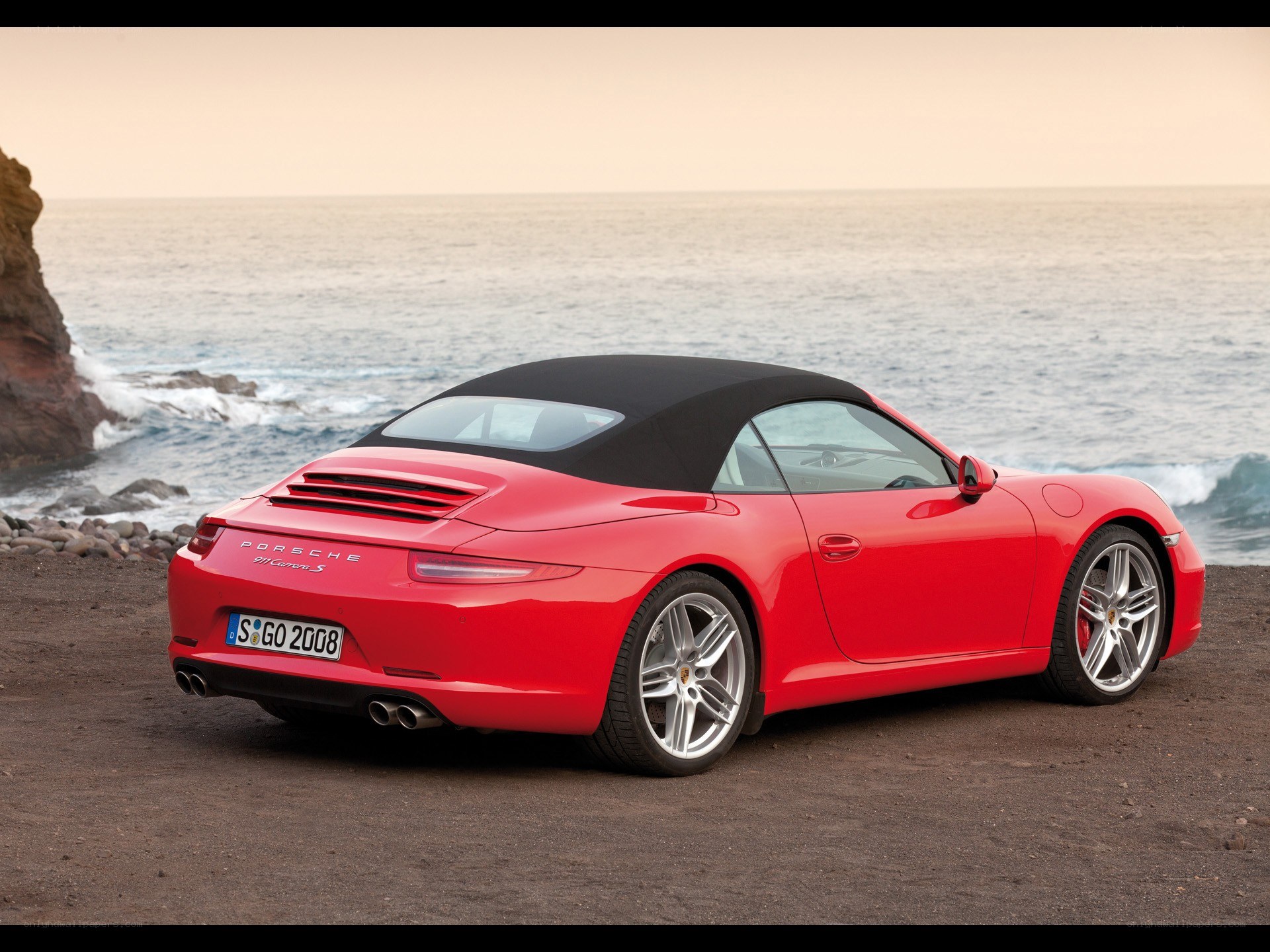 Red Porsche convertible by the sea