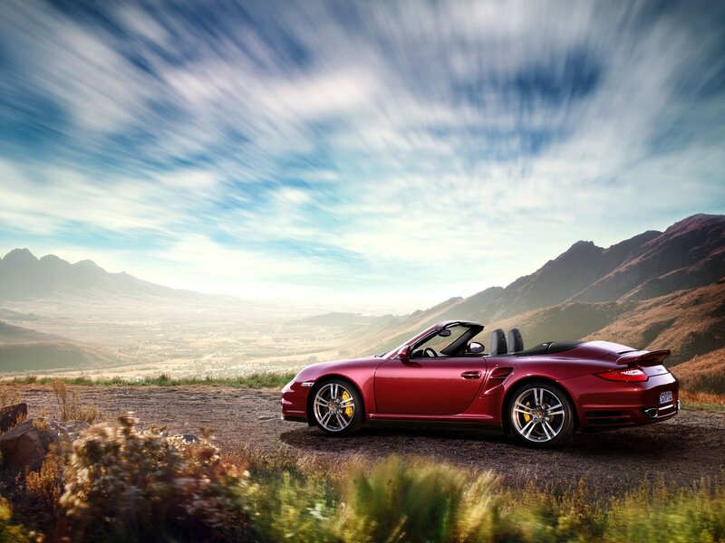 Red Porsche convertible on a mountain road