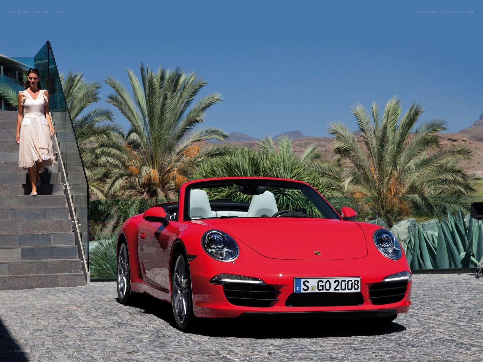Red Porsche convertible on cobblestone